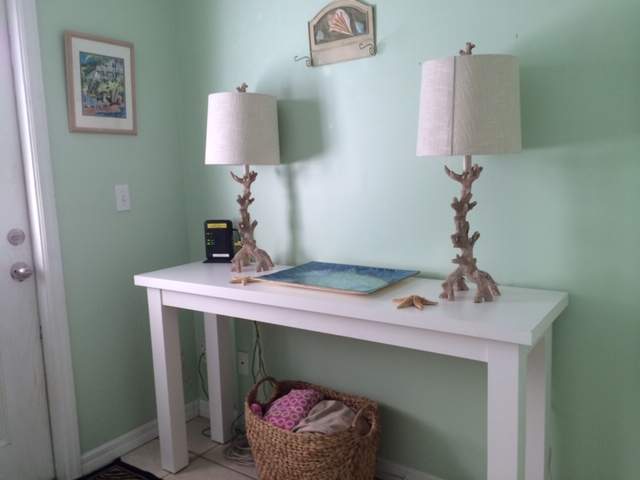 Side table near front entrance, two lamps
